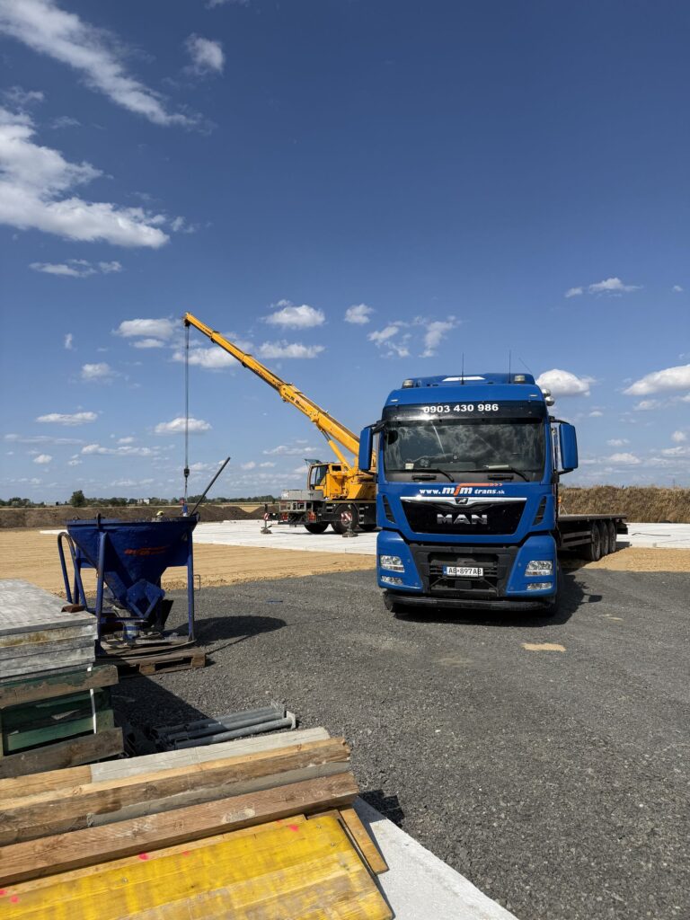 Auto s hydraulickou rukou MAN pri vykládke materiálu na stavbe