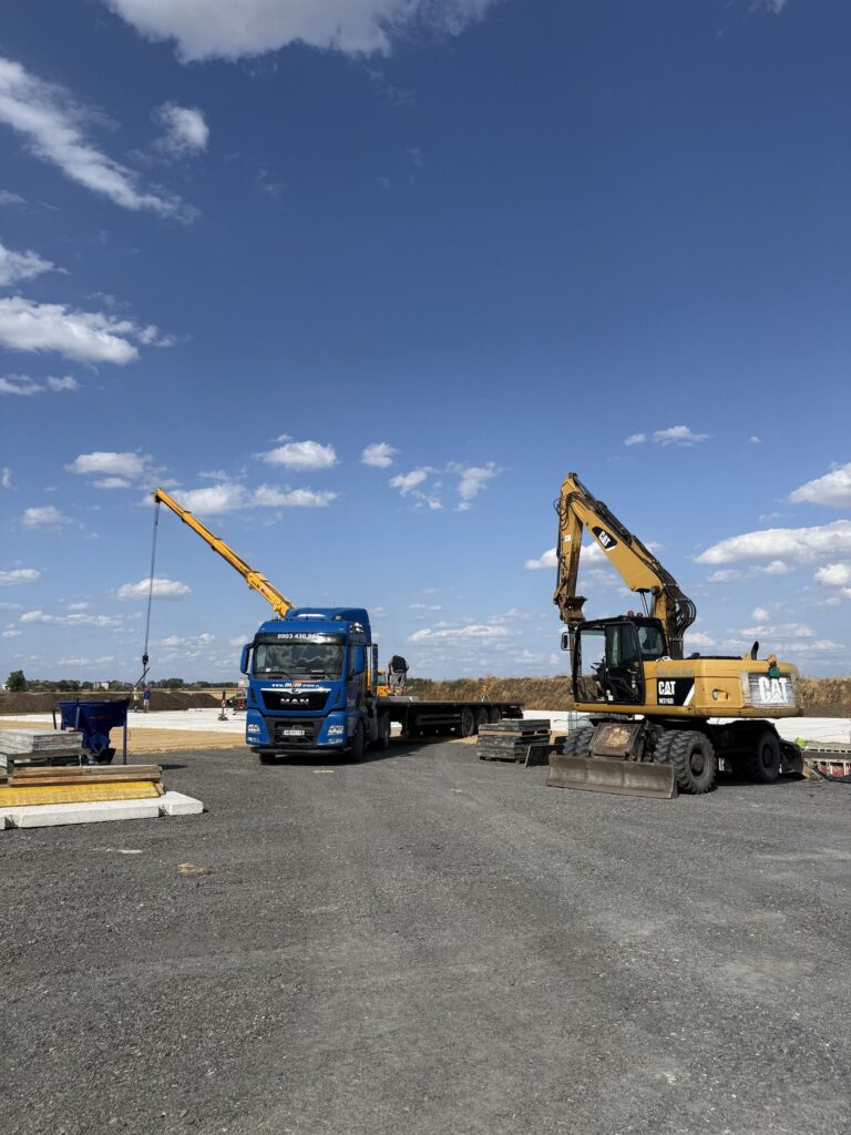 Autožeriav, valník MAN a rýpadlo CAT M316D na stavbe
