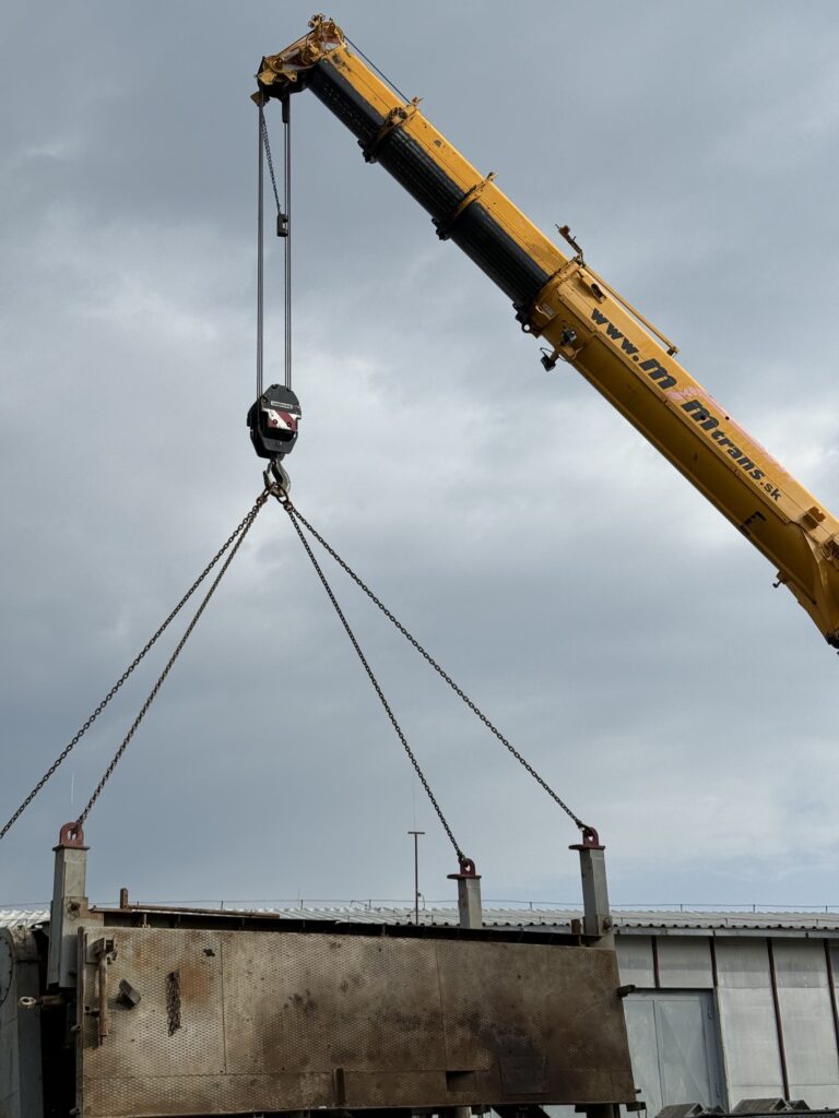 Autožeriav MJM Trans zdvíha oceľové bremeno na stavbe