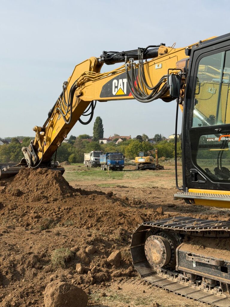 Pásové rýpadlo CAT 320E pri hĺbení a presune zeminy