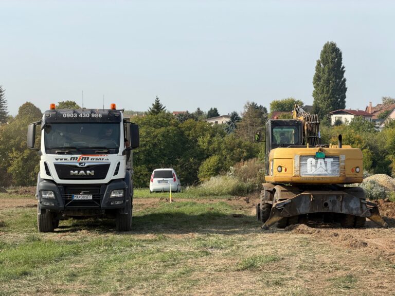 Sklápač MAN 8×8 a kolesové rýpadlo CAT M316D na stavenisku